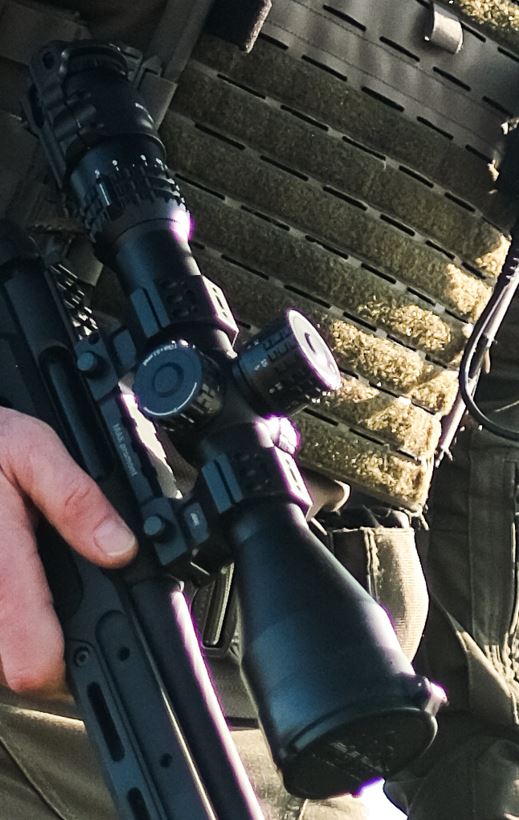 Gewehr mit Zielfernrohr in der Hand gehalten.