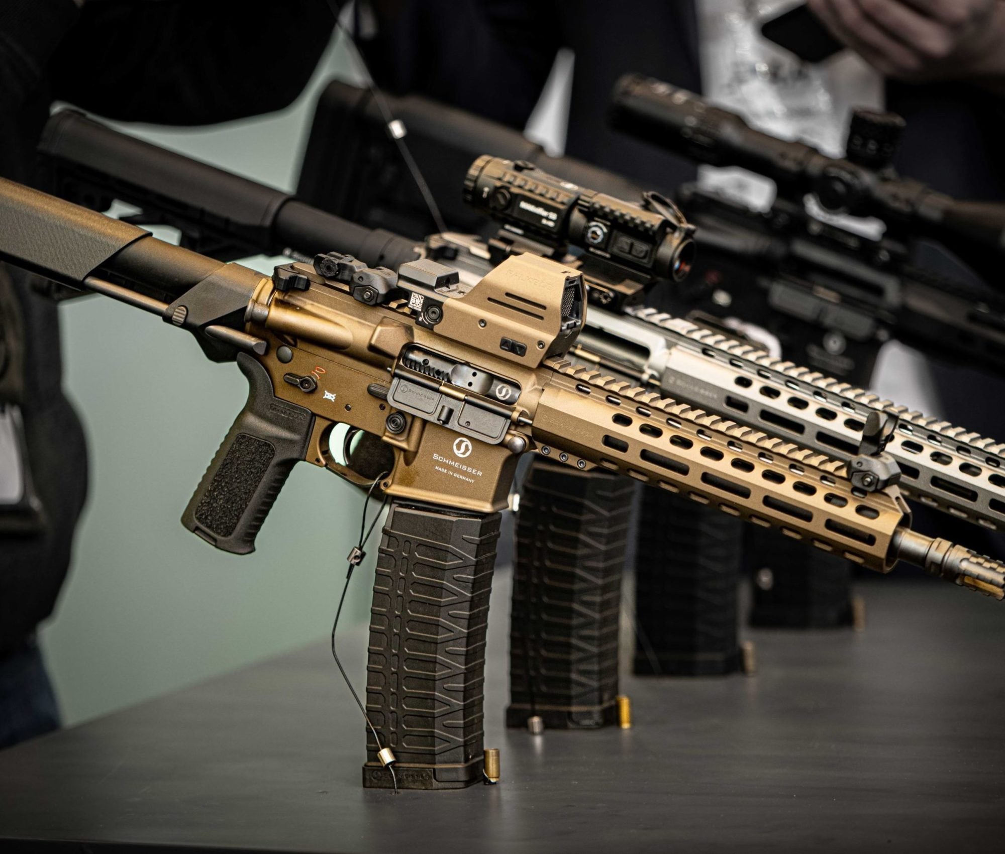 Drei Gewehre auf einem Tisch mit Zubehör.