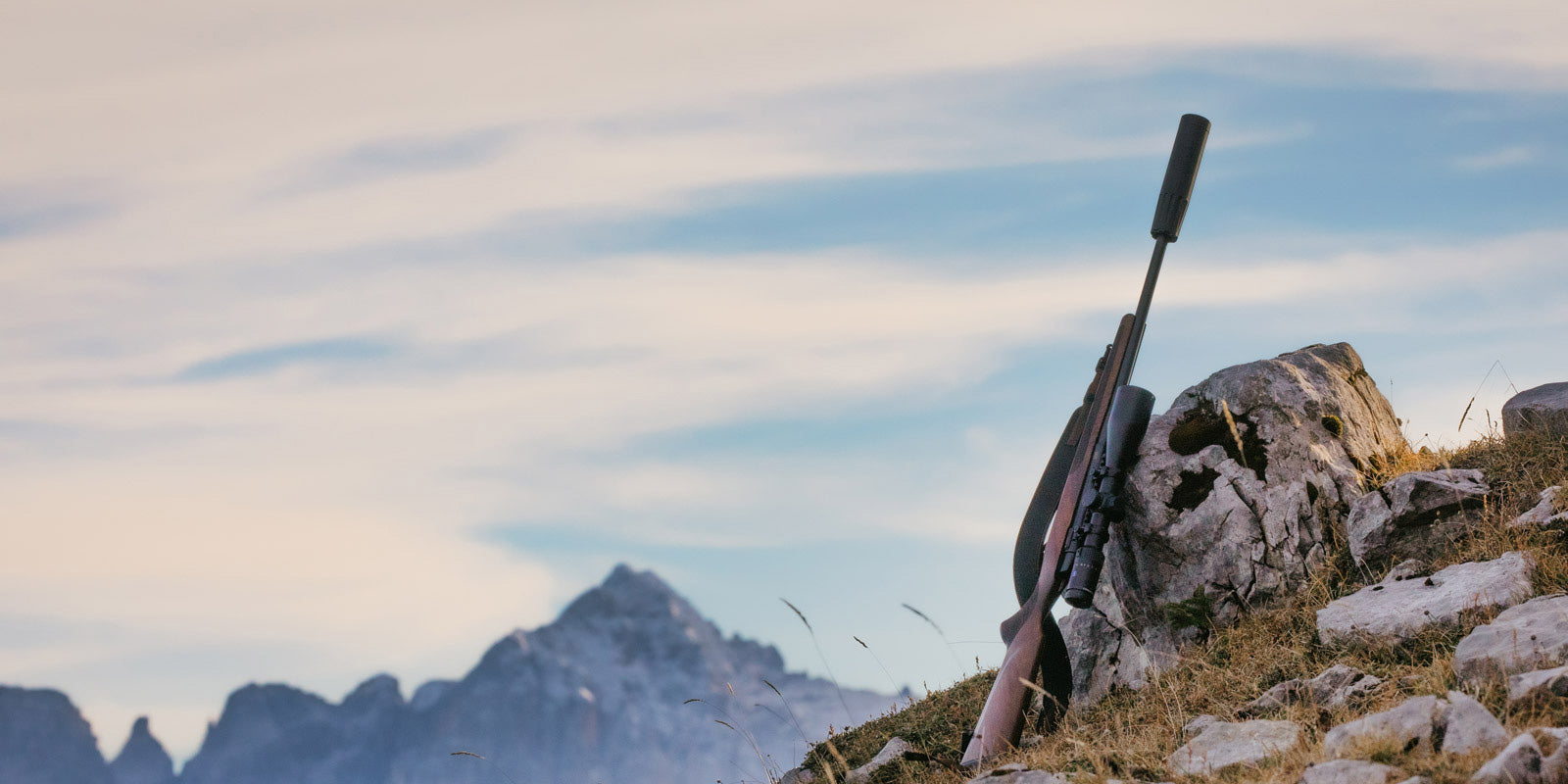 Gewehr leht am Stein Berge im Hintergrund